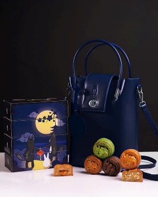 A blue purse and a box of cookies

Description automatically generated