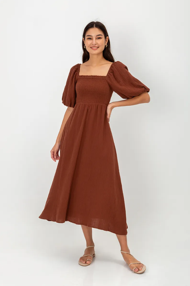 A person in a brown dress

Description automatically generated