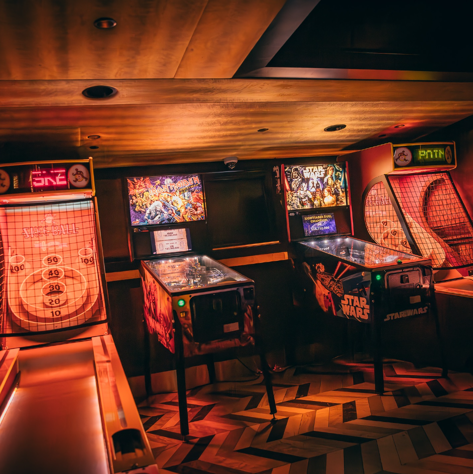 A room with arcade machines and a wooden ceiling

Description automatically generated